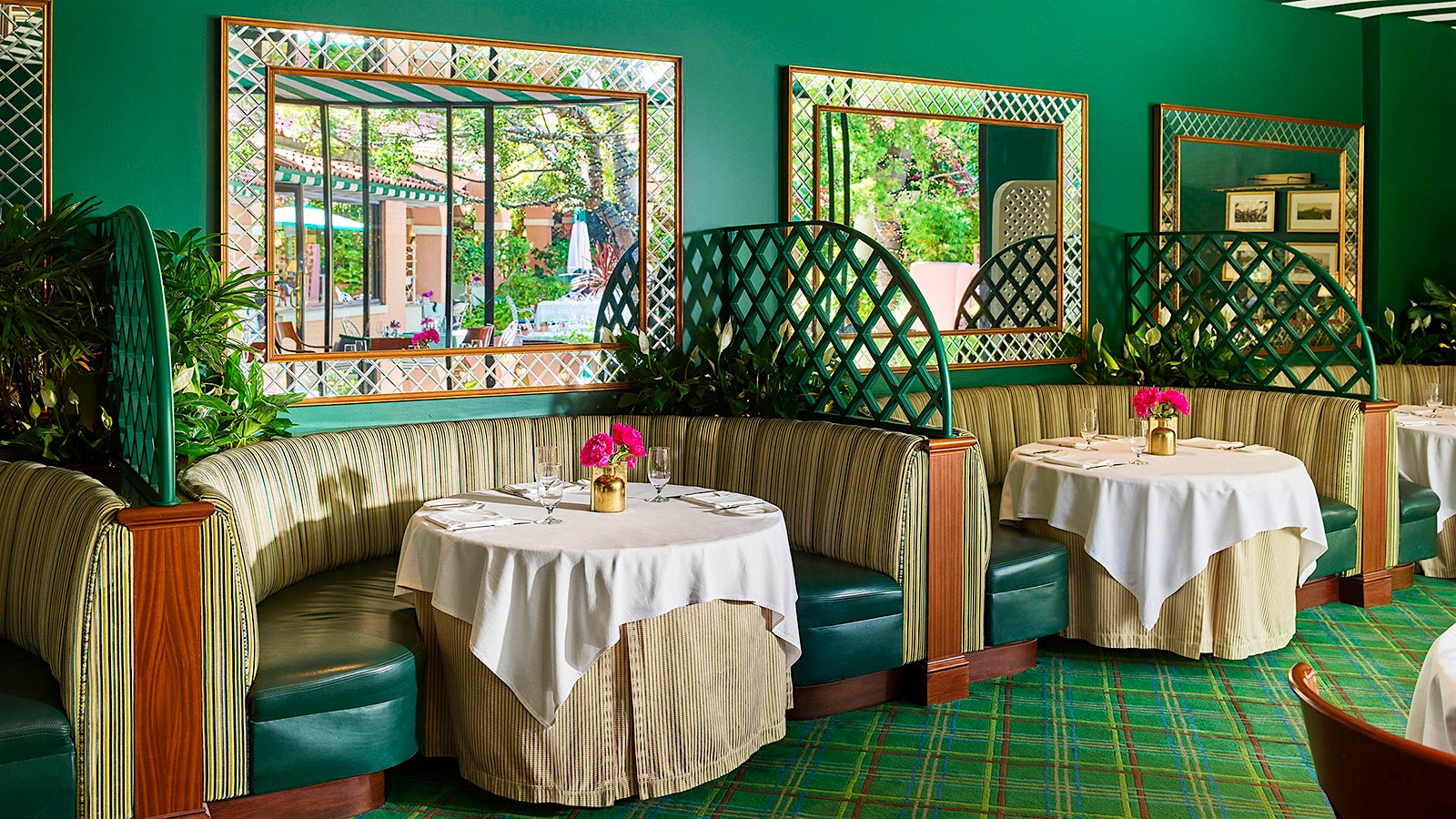 Green benches, green walls, a green-and-white ceiling and mirrors in the dining room at the Beverly Hills Hotel’s Polo Lounge